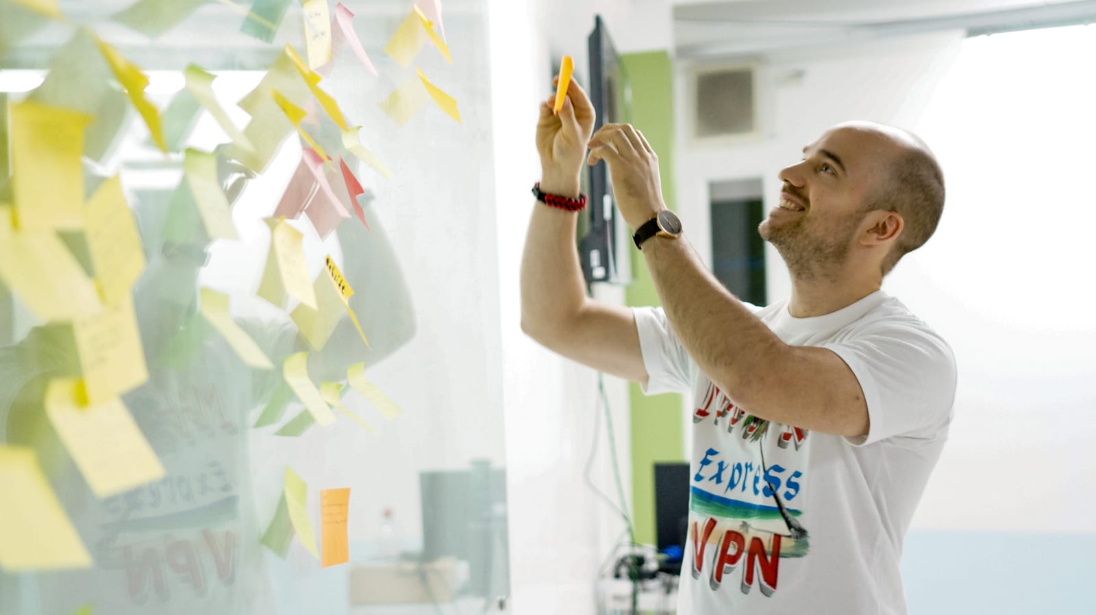 A client mapping ideas on a sticky-note wall during a workshop at TopData